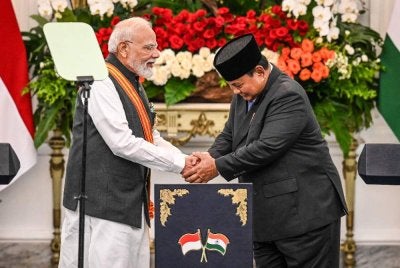Narendra Modi (kiri) berjabat tangan dengan Presiden Indonesia, Prabowo Subianto, selepas menghadiri sidang akhbar bersama di Istana Merdeka, Jakarta. Foto: AFP