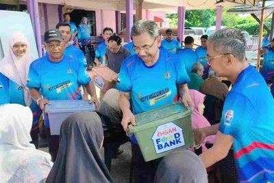 Azman (tengah) menyampaikan sumbangan kepada golongan asnaf dalam program 'Ride For Patuh' dan advokasi kepenggunaan bersama komuniti peringkat negeri Pahang di Masjid Kampung Padang Rumbia, Pekan pada Khamis.