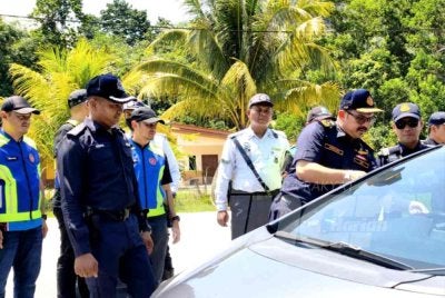Mohd Misuari (dua dari kiri) memeriksa kenderaan pada Ops PeWA dan Ops Bersepadu Dadah terhadap kenderaan perdagangan di SPK JPJ Laloh, Kuala Krai pada Khamis.