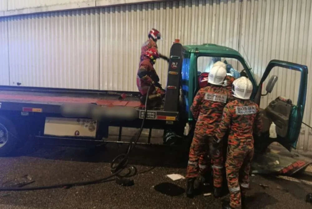 Anggota bomba sedang mengeluarkan mangsa tersepit dalam kemalangan di sini pada Jumaat.