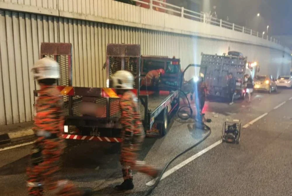 Anggota bomba sedang mengeluarkan mangsa tersepit dalam kemalangan di sini pada Jumaat.