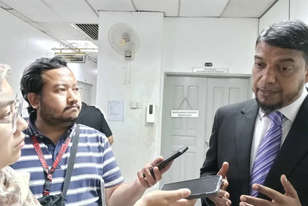 Muhammad Rafique (kanan) ditemui selepas prosiding di Mahkamah Sesyen Johor Bahru.