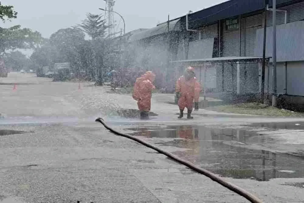 Anggota bomba turut menjalankan kerja-kerja ‘spill control’ menggunakan bahan pengikat kimia sebelum sisa tumpahan dikutip dan dimasukkan ke dalam tong khas (salvage drum). Foto: JBPM Perak