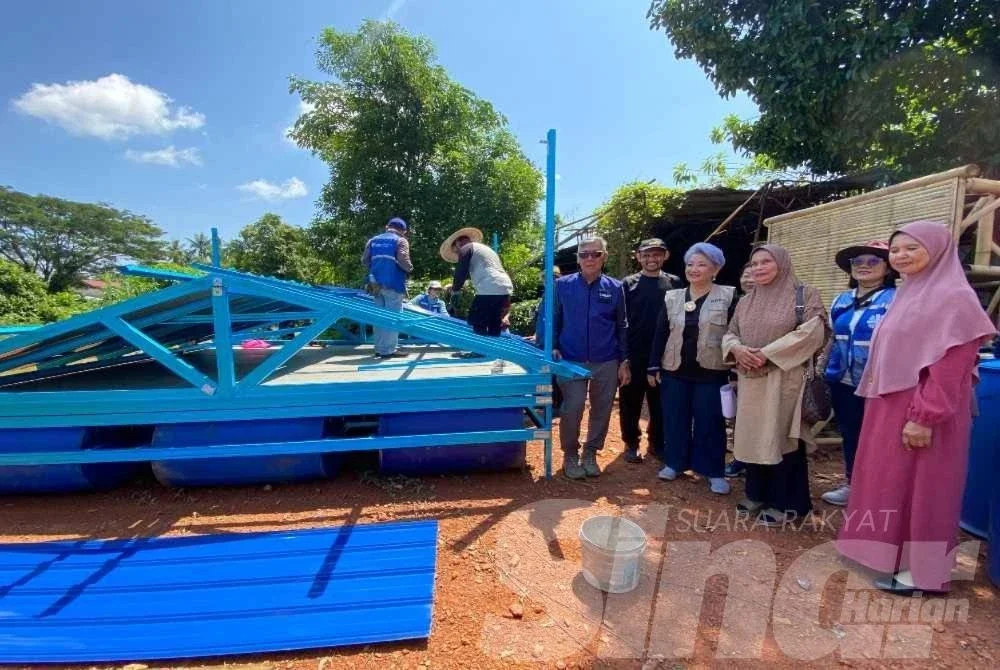 Wan Kasma (tiga,kanan) serta ahli jawatankuasa lain amat bersyukur apabila masjid itu menerima sebuah rumah rakit sumbangan KDRN yang boleh dijadikan dapur terapung bagi menghadapi musim tengkujuh akan datang. Foto HAZELEN LIANA KAMARUDIN