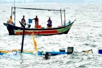 Kerja-kerja mengapungkan sebuah bot yang digunakan untuk aktiviti mencandat sotong yang karam dalam kejadian pada 3 Julai lalu. 