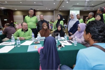 Mustakim (kiri) bertemu peserta Program Literasi Kewangan 'Cilik-Cilik Dah Celik' ke Pantai Timur yang diadakan di Hotel Grand Puteri di Kuala Terengganu pada Jumaat.