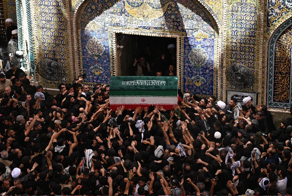 Orang ramai bersama-sama mengusung keranda Khamenei ketika perarakan pengebumiannya di Makam Imam Ali, Najaf.