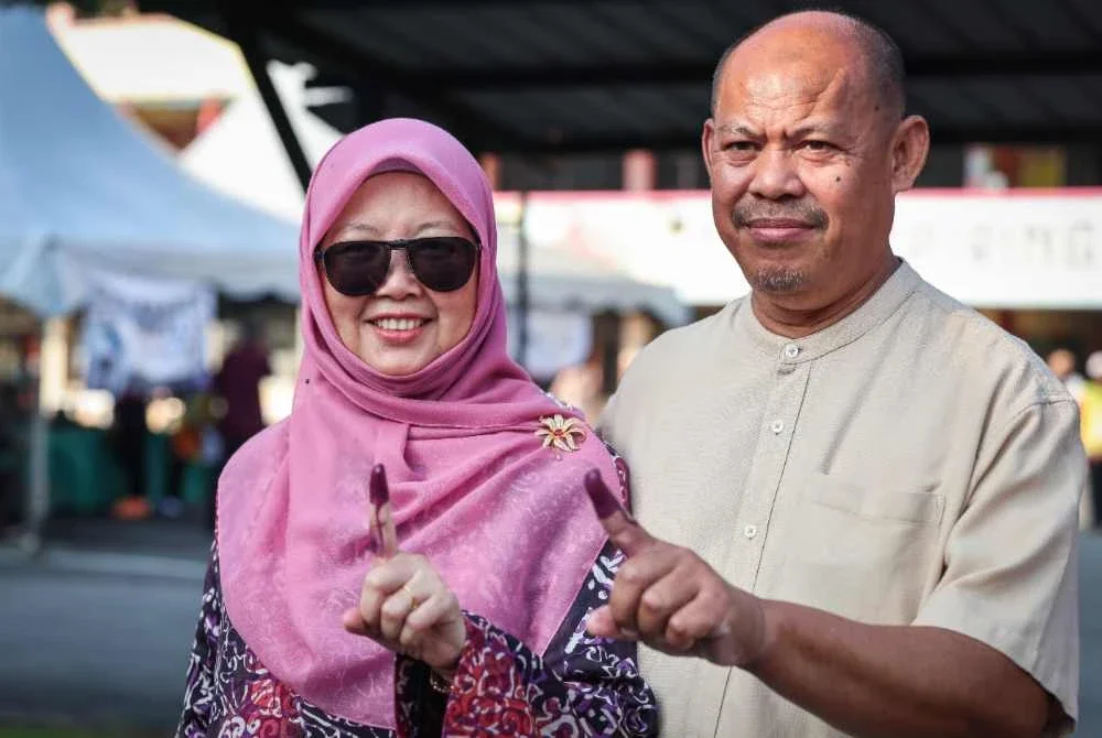 Dr Zaliha (kiri) bersama suami, Dr Ahmad Adzlan Musa selesai mengundi di Pusat Mengundi SMK Bandar Baru Uda bagi DUN Larkin sempena PRN Johor ke-16. Foto Bernama