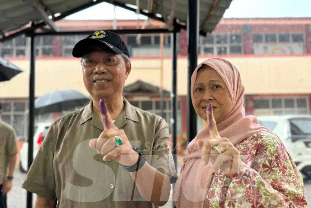 Muhyiddin dan isteri selesai membuang undi di pusat pengundian di SMK Sri Muar pada Sabtu.