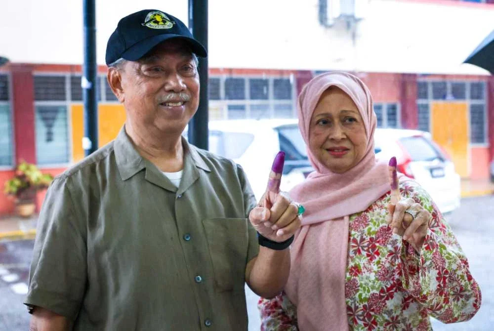 Muhyiddin dan isteri selesai mengundi bagi DUN N15 Maharani pada PRN Johor ke-16 di Sekolah Menengah Kebangsaan Sri Muar pada Sabtu. Foto Bernama