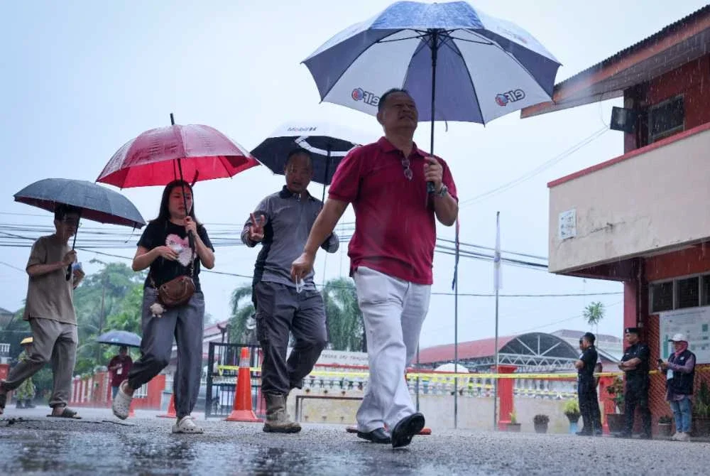 Hujan yang turun sejak awal pagi tadi tidak membataskan pergerakan pengundi untuk hadir bagi menunaikan tanggungjawab mereka. Foto Bernama