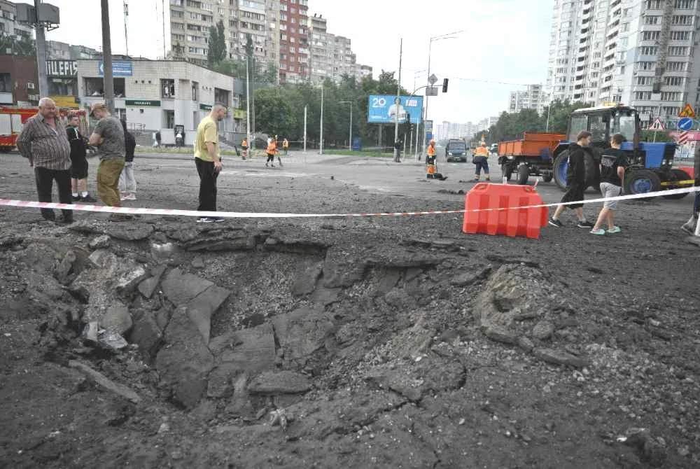 Orang ramai berdiri berhampiran sebuah kawah yang terbentuk akibat serangan peluru berpandu Rusia ke atas ibu negara Ukraine, Kyiv, pada awal pagi 11 Julai 2026. Foto AFP