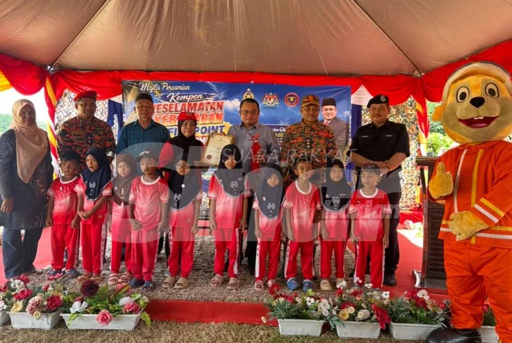 Hilmi (tiga dari kanan) menyampaikan sijil dan alat pemadam api kepada bomba cilik. Foto: ADILA SHARINNI WAHID