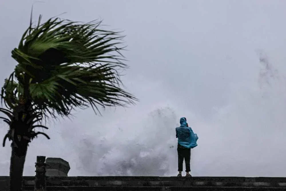 Seorang individu memerhatikan ombak besar yang menghempas pantai ketika Taufan Bavi melintasi perairan timur laut Taiwan di Keelung pada 11 Julai 2026. Foto AFP
