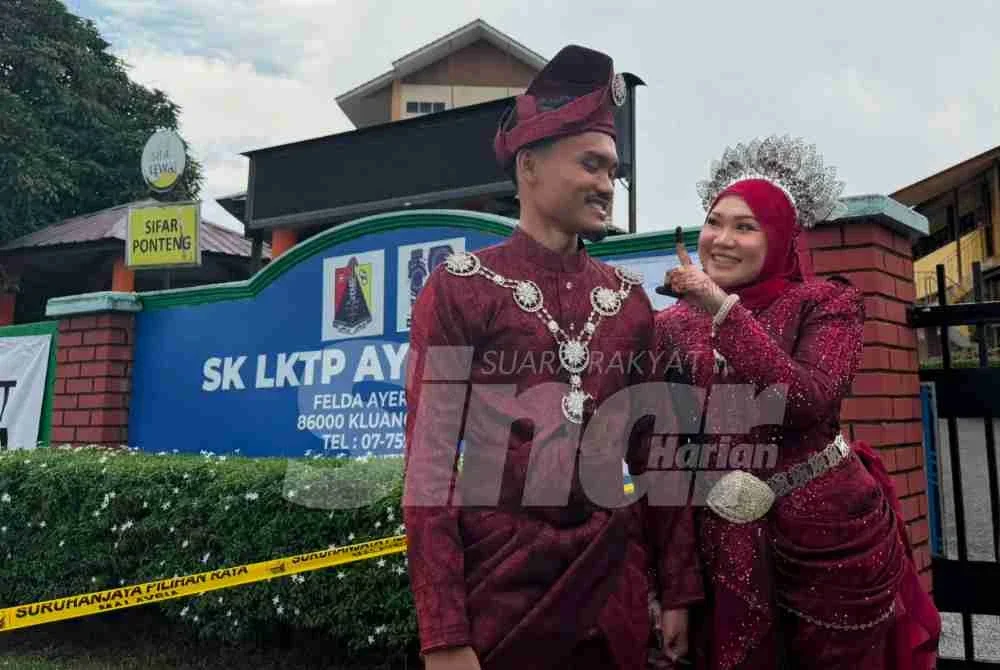 Aida ditemani pengantin lelaki, Raja Akmal menunjuk jari beliau yang dicelup dengan dakwat khas selepas selesai mengundi.