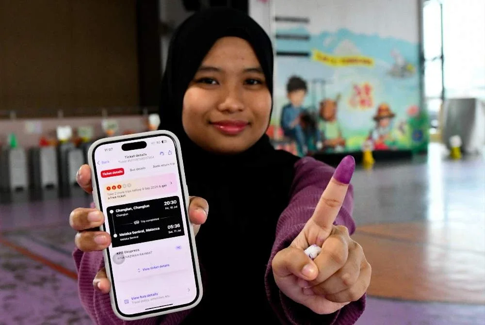 Aina Nazirah menunjukkan jari berdakwat selepas mengundi pada PRN Johor ke-16 di Sekolah Jenis Kebangsaan Cina Tongkang pada Sabtu. Foto: Bernama