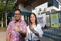 Nie Ching bersama calon DUN Bukit Permai, Mohamad Shafwan Ani menunjukkan jari tanda selesai menunaikan tanggungjawab sebagai pengundi.