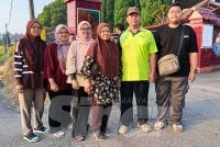 Maznah (tengah) bersama suami, Shahrom (dua dari kanan) serta anak-anak hadir seawal pagi bagi menunaikan tanggungjawab mengundi pada PRN Johor di pusat mengundi di SK Simpang Renggam, pada Sabtu.