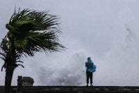Seorang individu memerhatikan ombak besar yang menghempas pantai ketika Taufan Bavi melintasi perairan timur laut Taiwan di Keelung pada 11 Julai 2026. Foto AFP