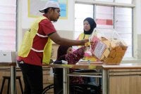 Petugas SPR membantu warga emas, Siti Anipah Kasbolah, 78, mengundi ketika melaksanakan tanggungjawab mengundi bagi kerusi Dewan Undangan Negeri (DUN) Senggarang pada PRN Johor ke-16 di Pusat Menggundi Sekolah Kebangsaan Senggarang pada Sabtu. Foto Bernama