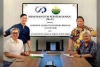 Nik Izani (duduk kanan) dan Roy Chok (duduk kiri) ketika sesi menandatangi MoU antara COOP OKB dan Solartech Sales & Service Sdn Bhd pada Isnin.