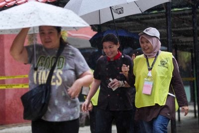 Petugas SPR membantu orang ramai yang hadir untuk mengundi bagi DUN N15 Maharani sempena PRN Johor ke-16 di Sekolah Menengah Kebangsaan Sri Muar pada Sabtu. Foto Bernama
