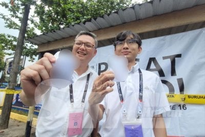 Boon Tsong (kiri) dan Jia Lee menunjukkan kertas catatan oleh PACA