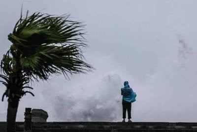 Seorang individu memerhatikan ombak besar yang menghempas pantai ketika Taufan Bavi melintasi perairan timur laut Taiwan di Keelung pada 11 Julai 2026. Foto AFP