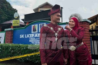 Aida ditemani pengantin lelaki, Raja Akmal menunjuk jari beliau yang dicelup dengan dakwat khas selepas selesai mengundi.