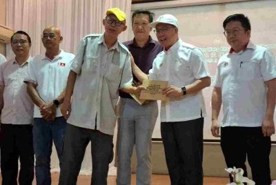 Kor Ming (dua dari kanan) menyempurnakan simbolik penyerahan Pemberian Wang Ihsan Bencana Ribut Bercham di Kampung Bercham di Ipoh pada Ahad.