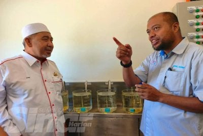 Dr Izani (kiri) melihat proses penapisan air semasa mengadakan lawatan kerja ke tapak pembinaan LRA Chicha 2 di Pasir Hor, Kota Bharu pada Ahad. Foto: HAZELEN LIANA KAMARUDIN