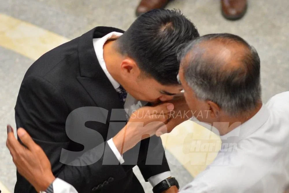 Syed Saddiq mencium tangan bapanya. Foto: ASRIL ASWANDI SHUKOR