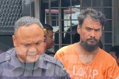 Tertuduh (kanan) yang keluar dari lokap mahkamah pada Isnin selepas dijatuhi hukuman. 