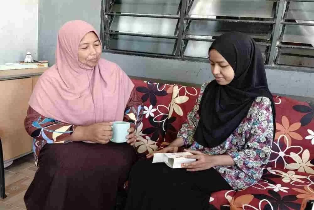Ummi Husna (kanan) makan ubat oral kemoterapi sambil ditemani ibunya di Kampung Padang Cenderai, Kuala Nerang.