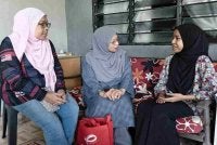 Ummi Husna (kanan) menerima kunjungan Zuraini (tengah) di di Kampung Padang Cenderai, Kuala Nerang.