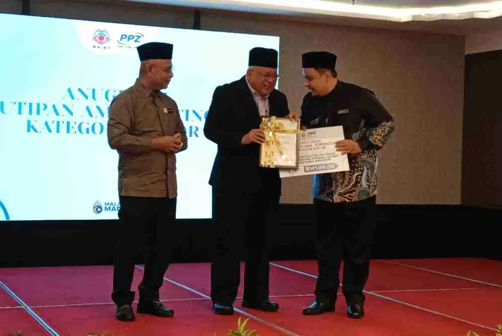 Ahmad Azam (tengah) ketika menyampaikan anugerah kepada amil terlibat.