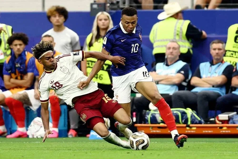 Bintang muda Sepanyol, Lamine Yamal (kiri) melakukan terjahan keras bagi menghalang larian Kylian Mbappe pada aksi separuh akhir Piala Dunia di Arlington. Foto: Agensi