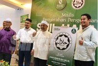 Mohd Asri (dua dari kiri) bersama Mohd Nassuruddin (tiga dari kiri) dan Mohd Nazif (kanan) pada Majlis Penyerahan Pengesahan Sijil Halal 17 Cawangan Nasken Coffee di Kota Bharu pada Rabu. 