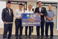 Mohamad (tengah) menyaksikan penyerahan cek cura bernilai RM2 juta yang diserahkan oleh Mohamad Kairi (dua dari kiri) kepada Timbalan Pengarah Sektor Pembelajaran JPNPP, Mohamad Said Ibrahim (dua dari kanan) di Majlis Taklimat Guru Penyelaras MPDCA 2026 di Bertam Resort pada Rabu.
