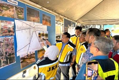 Nanta (dua dari kanan) yang melihat laporan projek yang dipaparkan pada papan kenyataan.
FOTO SINAR HARIAN - ADILA SHARINNI WAHID