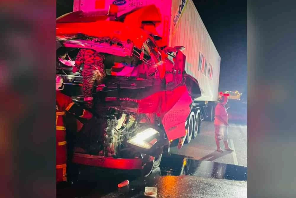 Pasukan bomba mengeluarkan mangsa yang tersepit di tempat duduk pemandu treler jenis Volvo dalam kemalangan di Kilometer 1, Jalan Tebuk Marso, Lebuhraya Persekutuan awal pagi Jumaat.
