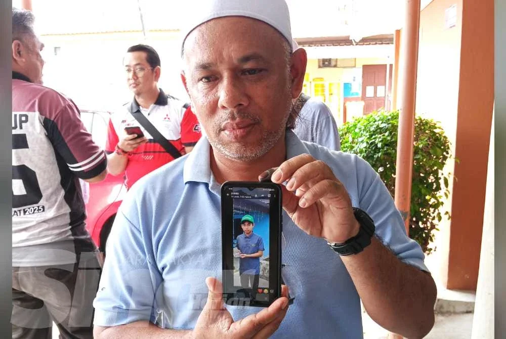 Kamaruzaman menunjukkan gambar arwah anaknya.