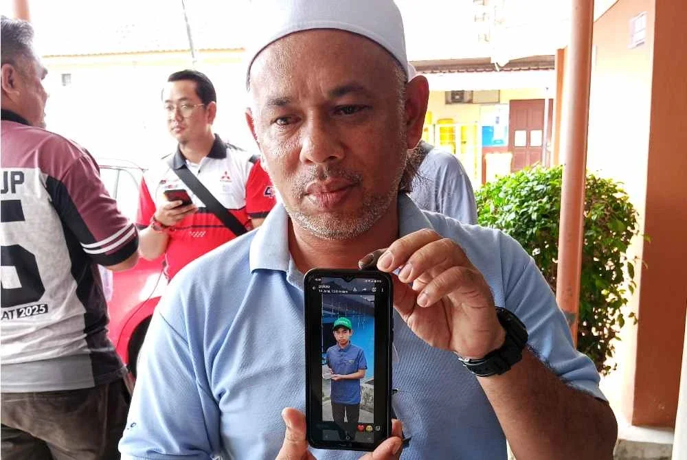 Kamaruzaman menunjukkan gambar arwah anaknya.