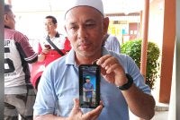 Kamaruzaman menunjukkan gambar arwah anaknya.