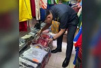 Pegawai KPDN Johor memeriksa jersi tiruan yang dirampas dalam operasi penguatkuasaan. Foto KPDN Johor