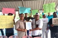 Shukor (kanan) menyerahkan memorandum kepada Muhammad Hanafi bagi meminta kerajaan negeri mengambil tindakan sewajarnya untuk membela nasib nelayan di kawasan terbabit.