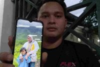 Nur Arif menunjukkan gambar Nur Atikah dan anaknya, Nur Atiya Sofiya.