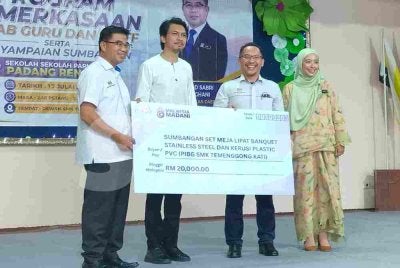 Muhammad Kamil (dua dari kiri) menyerahkan replika cek sumbangan kepada penerima sempena Program Pemerkasaan Kelab Guru dan Staf serta Penyampaian Sumbangan Sekolah-sekolah Parlimen Padang Rengas di Dewan SMK Tun Perak, pada Jumaat.