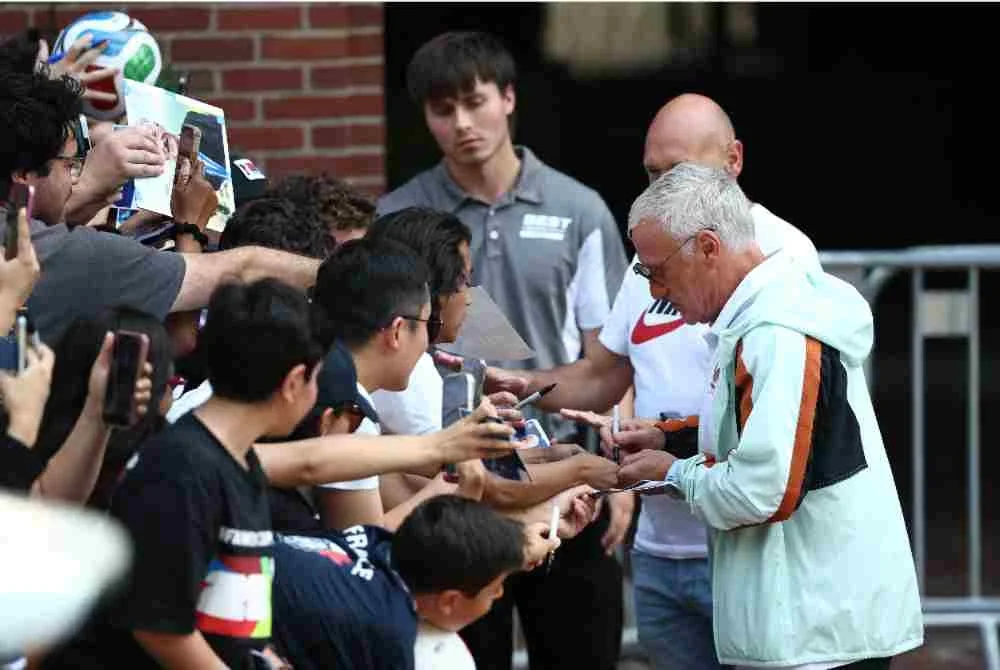 Deschamps (kanan) menandatangani autograf ketika skuad Les Bleus meninggalkan hotel di Boston untuk menuju ke Miami menjelang aksi penentuan tempat ketiga Piala Dunia 2026 menentang England.