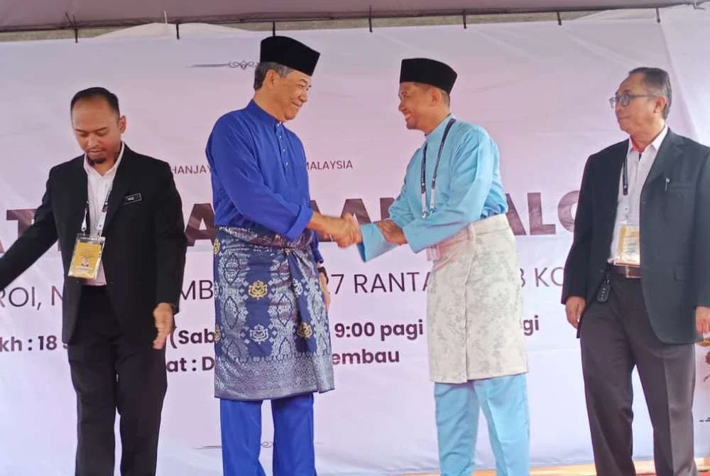 Calon PH, Dr Azizul Hakim Mahdi (dua dari kanan) dan Timbalan Pengerusi BN merangkap Timbalan Presiden UMNO, Datuk Seri Mohamad Hasan (dua dari kiri) ketika diumumkan sebagai calon satu lawan satu di DUN Rantau selepas proses penamaan calon di Dewan Seri Rembau pada Sabtu.